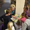 Dzieci przeglądają książki przygotowane przez Panią bibliotekarkę.